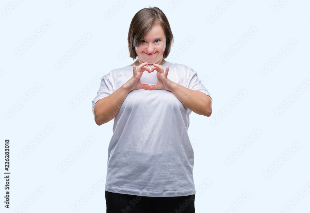 Young adult woman with down syndrome over isolated background smiling in love showing heart symbol and shape with hands. Romantic concept. Young adult woman with down syndrome over isolated background smiling in love showing heart symbol and shape with hands. Romantic concept.