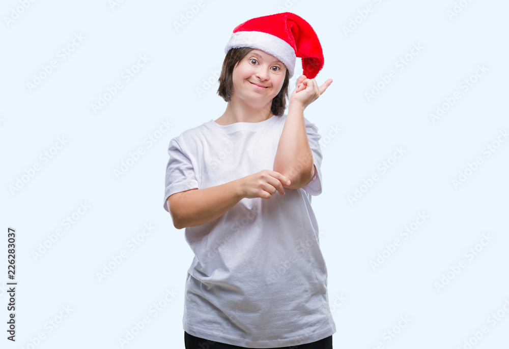 Young adult woman with down syndrome wearing christmas hat over isolated background with a big smile on face, pointing with hand and finger to the side looking at the camera. Young adult woman with down syndrome wearing christmas hat over isolated background with a big smile on face, pointing with hand and finger to the side looking at the camera.