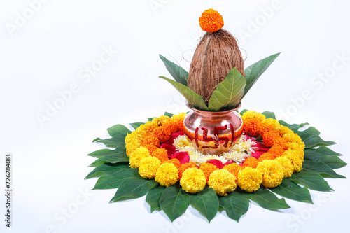Copper Kalash with coconut , leaf and floral decoration on a white background. essential in hindu puja. photo