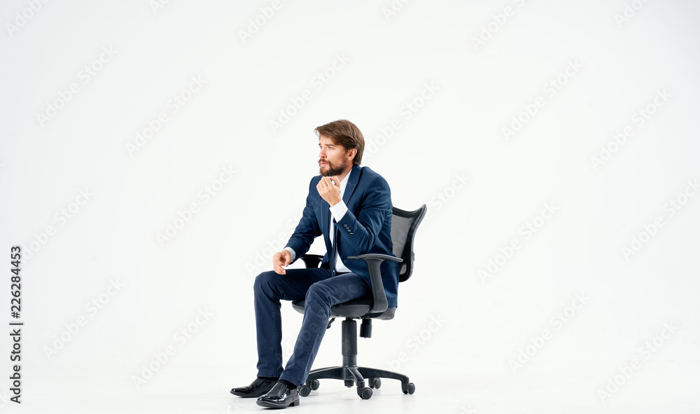 man in a suit sitting in a chair man in a suit sitting in a chair