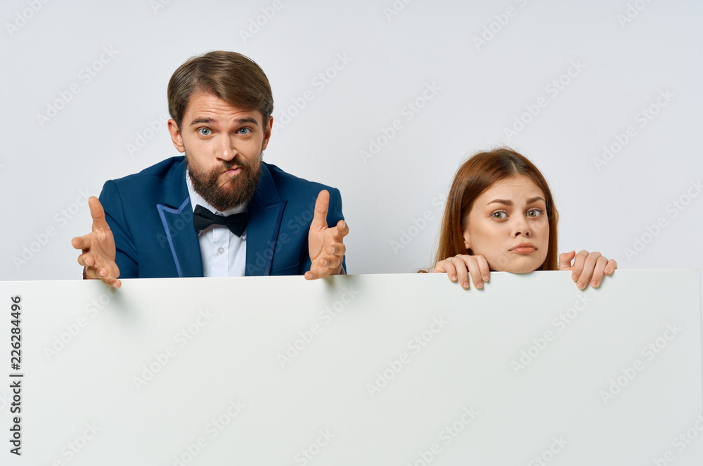 man and woman stand behind big white mockup man and woman stand behind big white mockup