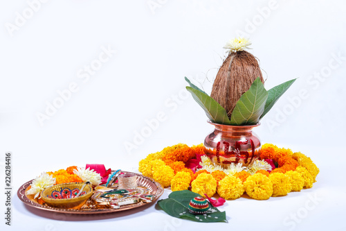 Schilderij op canvas Copper Kalash with coconut , leaf and floral decoration on a white background