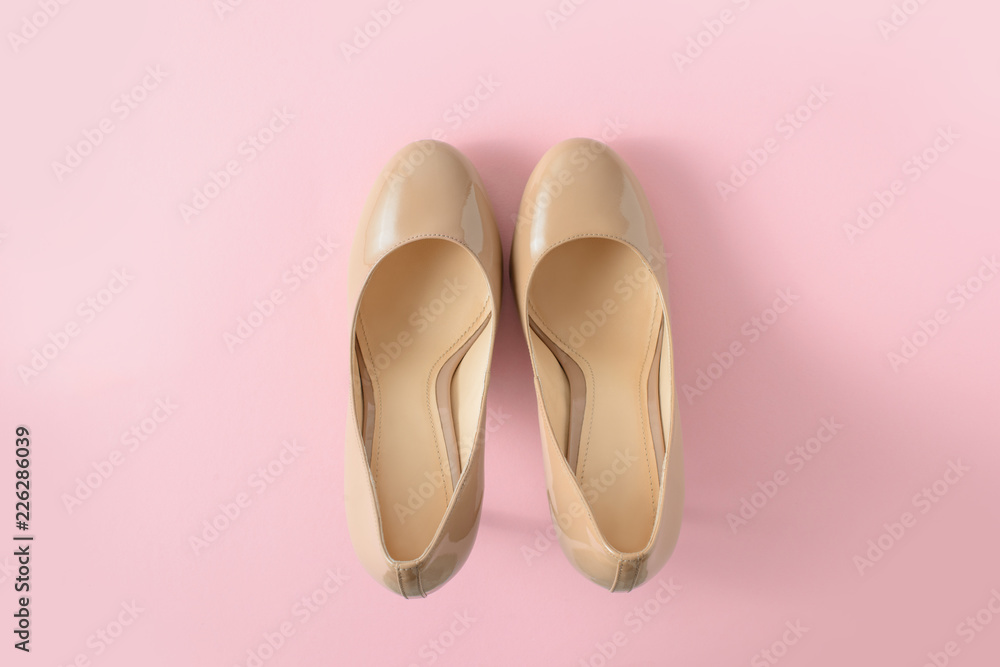 Fototapeta premium Beige women high heel shoes on pink background. Fashion blog look. Top view, flat lay.