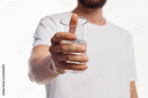 man holds a glass of water in his hand