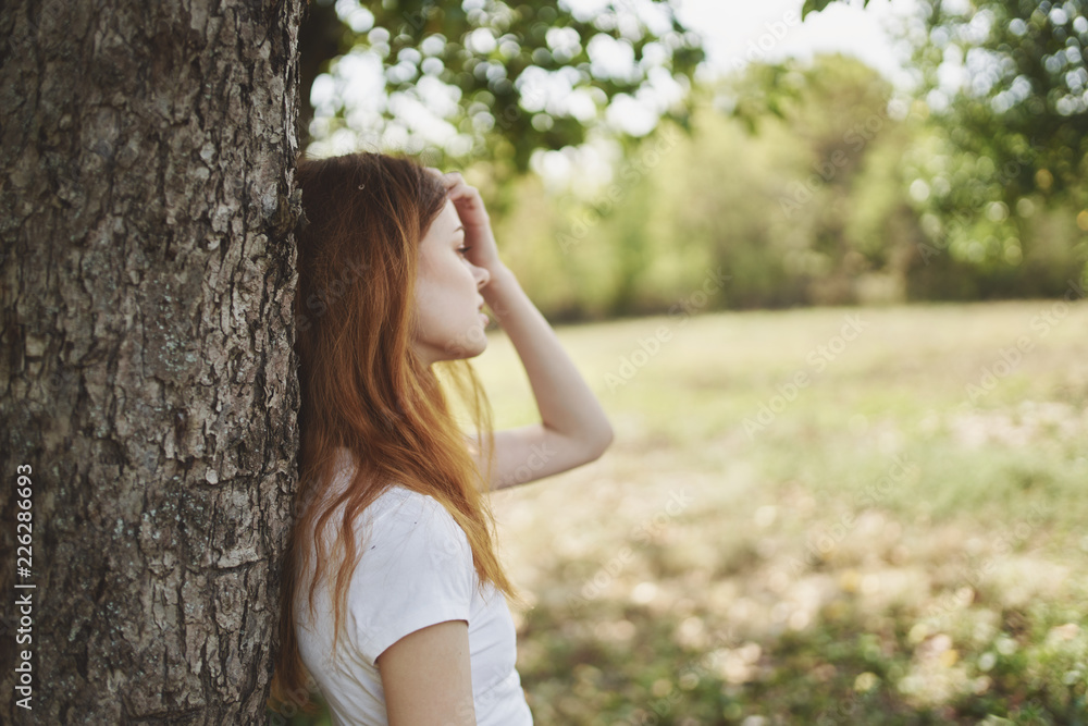 a woman is leaning on a tree a woman is leaning on a tree