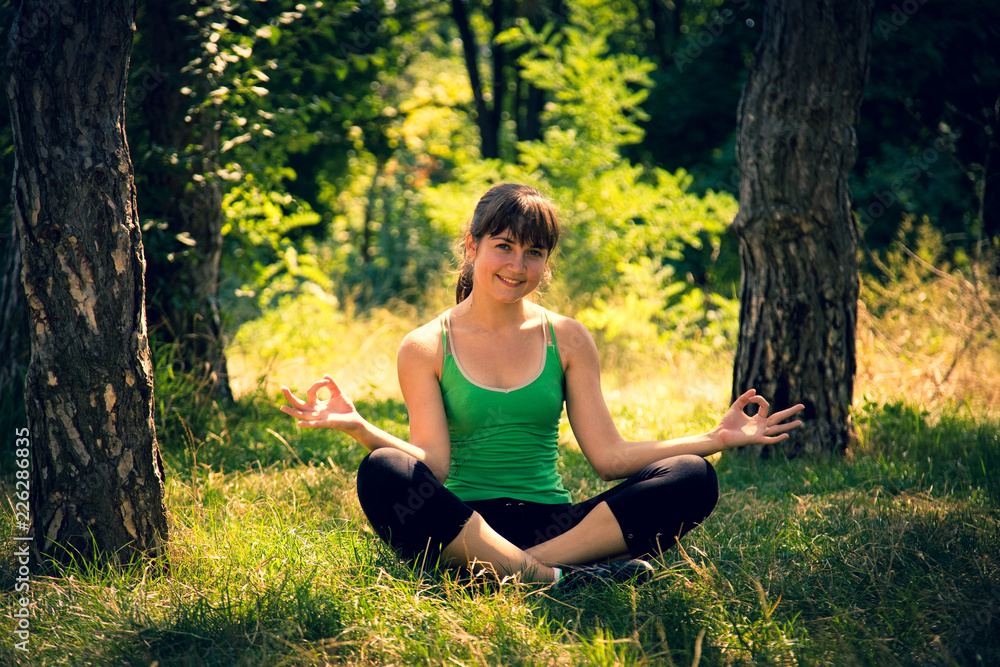 Young beautiful girl doing physical exercises in a park. Summer season Young beautiful girl doing physical exercises in a park. Summer season
