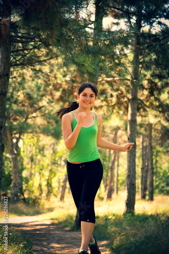Young beautiful girl doing physical exercises in a park. Summer season