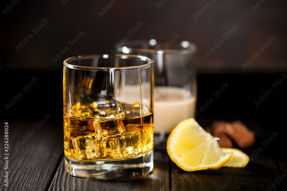 Whisky with ice and a lemon and creamy liqueur with chocolate Whisky with ice and a lemon and creamy liqueur with chocolate