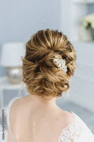 Bride sitting back on the bed, the morning of the bride, wedding hairstyle