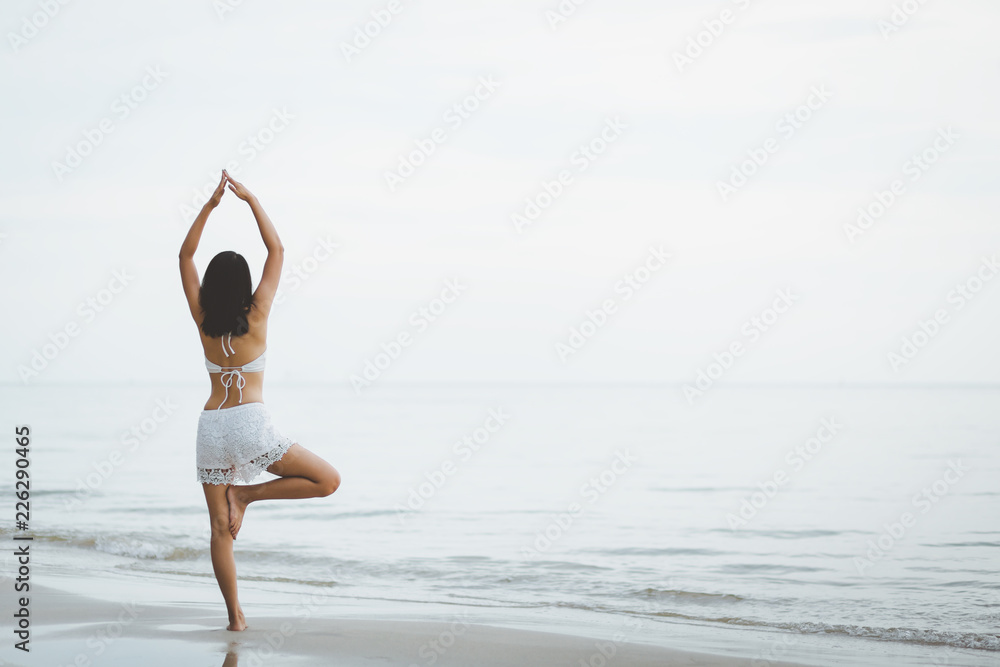 Travel woman yoga on beach