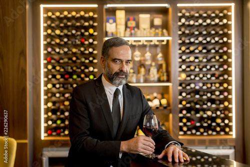 Handsome mature man tasting...