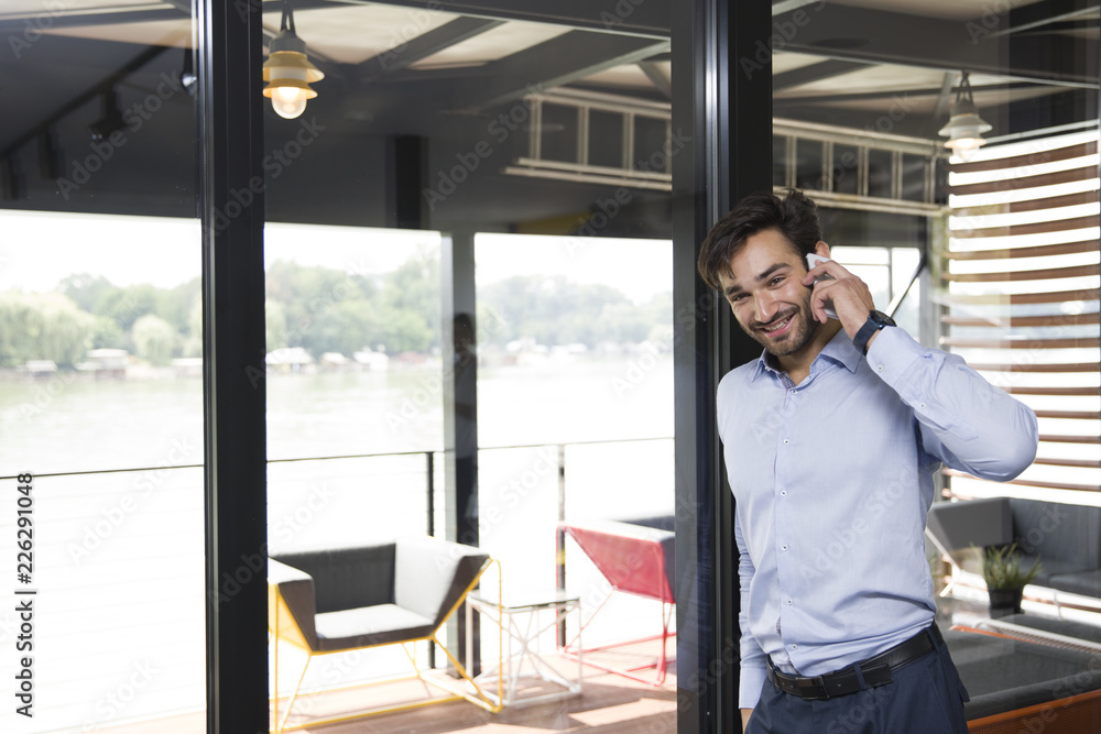 Young businessman using mobile phone in the office Young businessman using mobile phone in the office