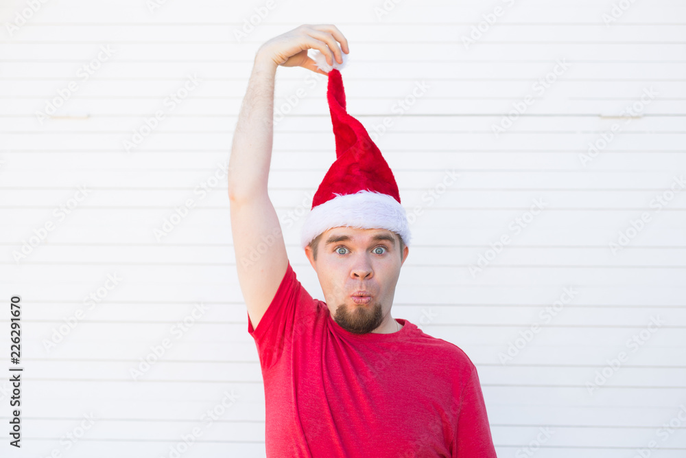 Holidays, christmas and people concept - funny handsome man in santa hat have fun on white background with copy space Holidays, christmas and people concept - funny handsome man in santa hat have fun on white background with copy space