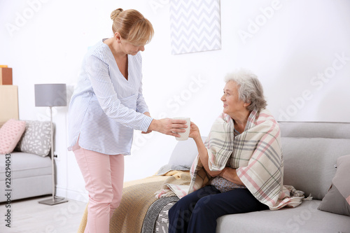 Caregiver giving cup of tea...