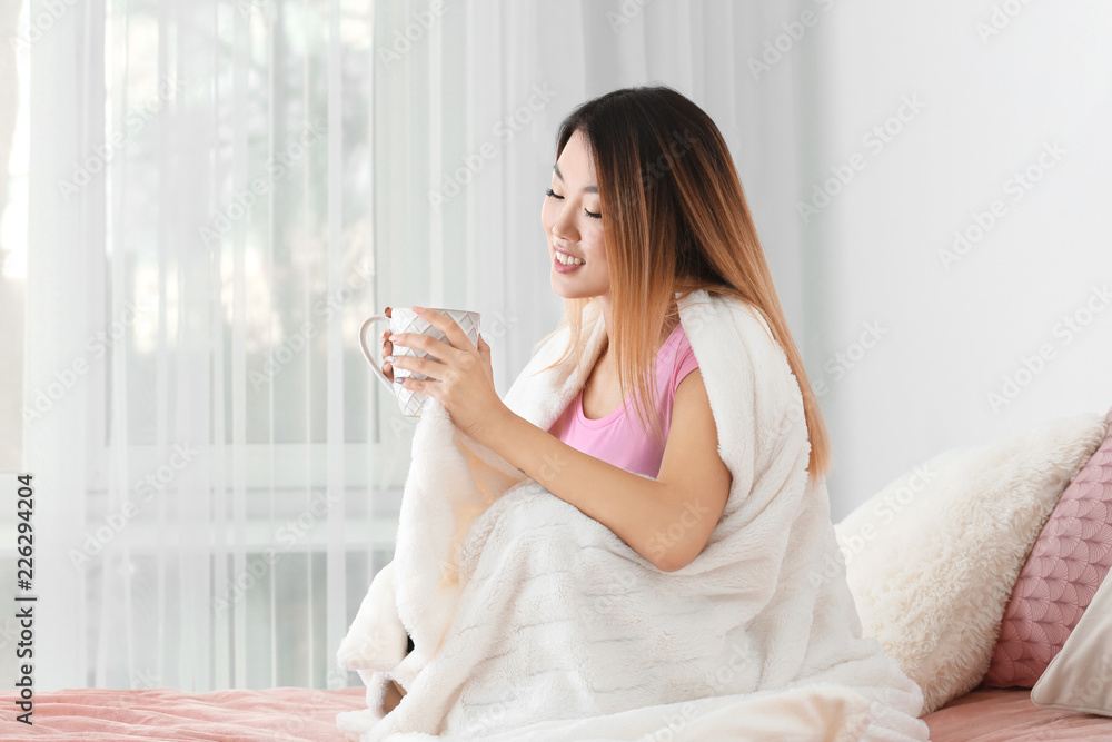 Beautiful smiling Asian woman with cup of tea at home Beautiful smiling Asian woman with cup of tea at home