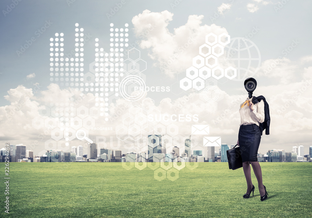 Camera headed woman standing on green grass against modern citys Camera headed woman standing on green grass against modern citys