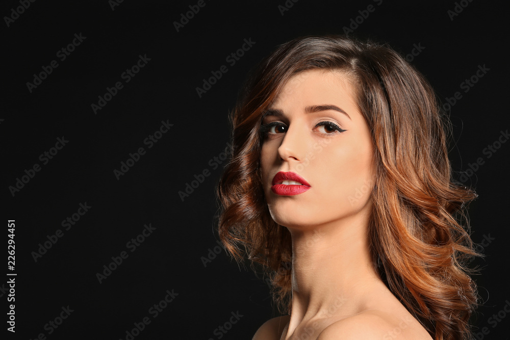 Attractive young woman with elegant makeup and long eyelashes on black background. Eyelash extensions Attractive young woman with elegant makeup and long eyelashes on black background. Eyelash extensions
