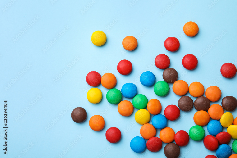 Tasty glazed candies and space for text on color background, top view
