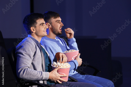 Young men watching movie in...