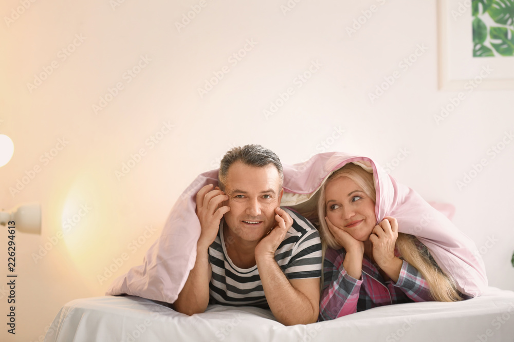 Senior couple under blanket in bed together Senior couple under blanket in bed together