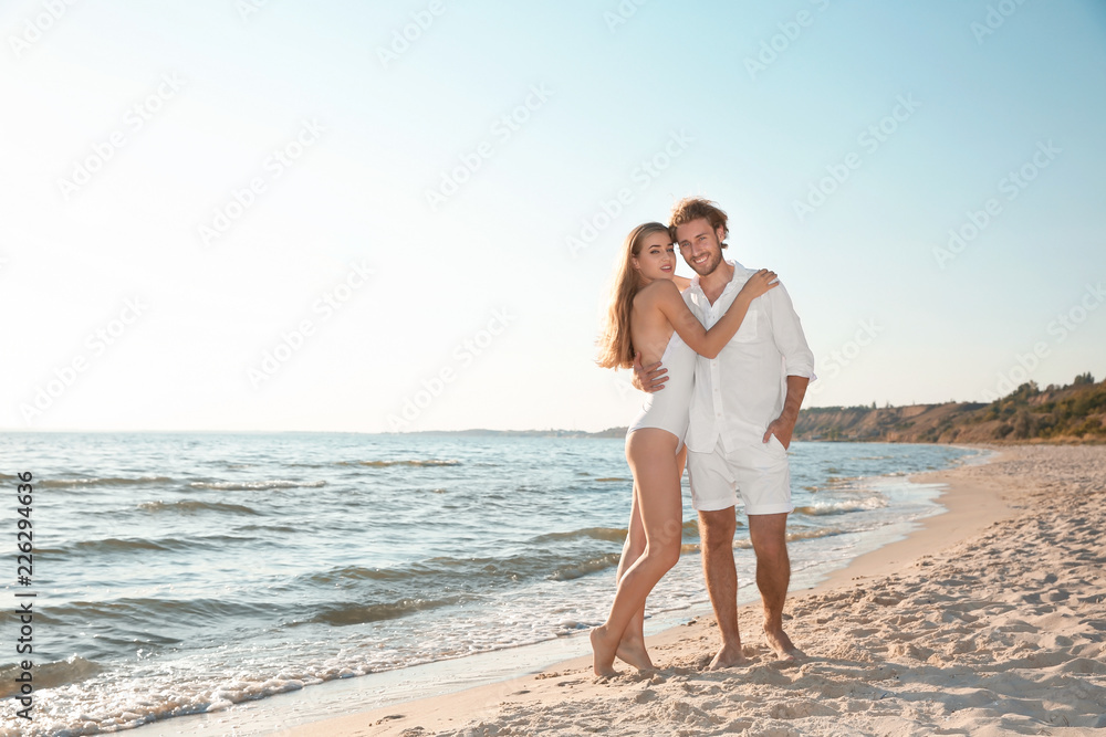 Romantic young couple spending time together on beach. Space for text