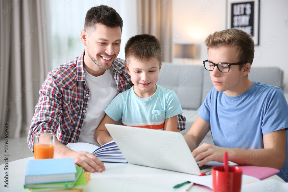 Children with father doing homework at home Children with father doing homework at home