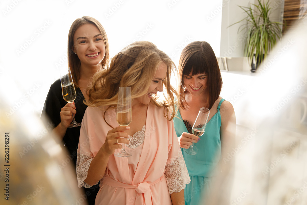 Women party. Girls party. Attractive funny girls in silk robes having fun  and drinking a champagne during celebration the bridal shower, at home.  Hen-party concept Stock Photo | Adobe Stock