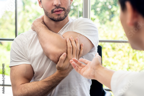 Canvas Print Sportsman patient consulting with doctor about muscule pain in clinic