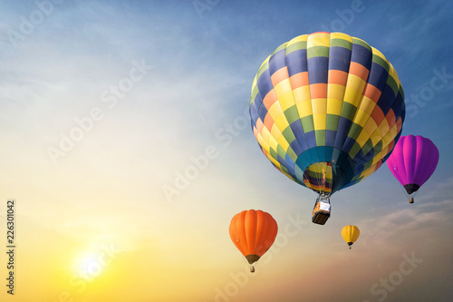 Colorful balloons floating in the sky at sunset.