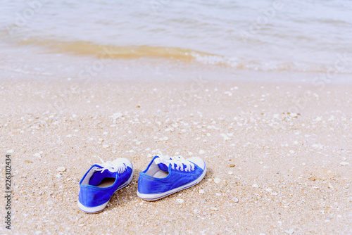 Life is journey, Blue sneaker on the beach. Travel Concept.