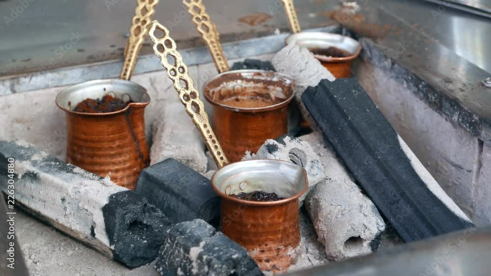 Turkish coffee being brewed by unidentified man on hot sand and charcoal. Turkish coffee being brewed by unidentified man on hot sand and charcoal.
