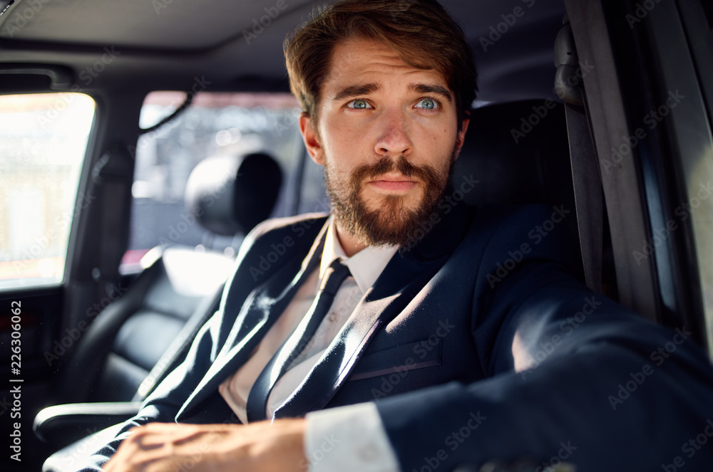 business man in blue suit sitting in the car