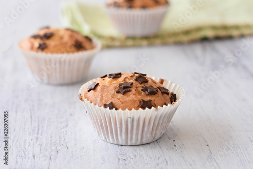Sweet delicious homemade vanilla muffins whit chocolate chips at white wooden background