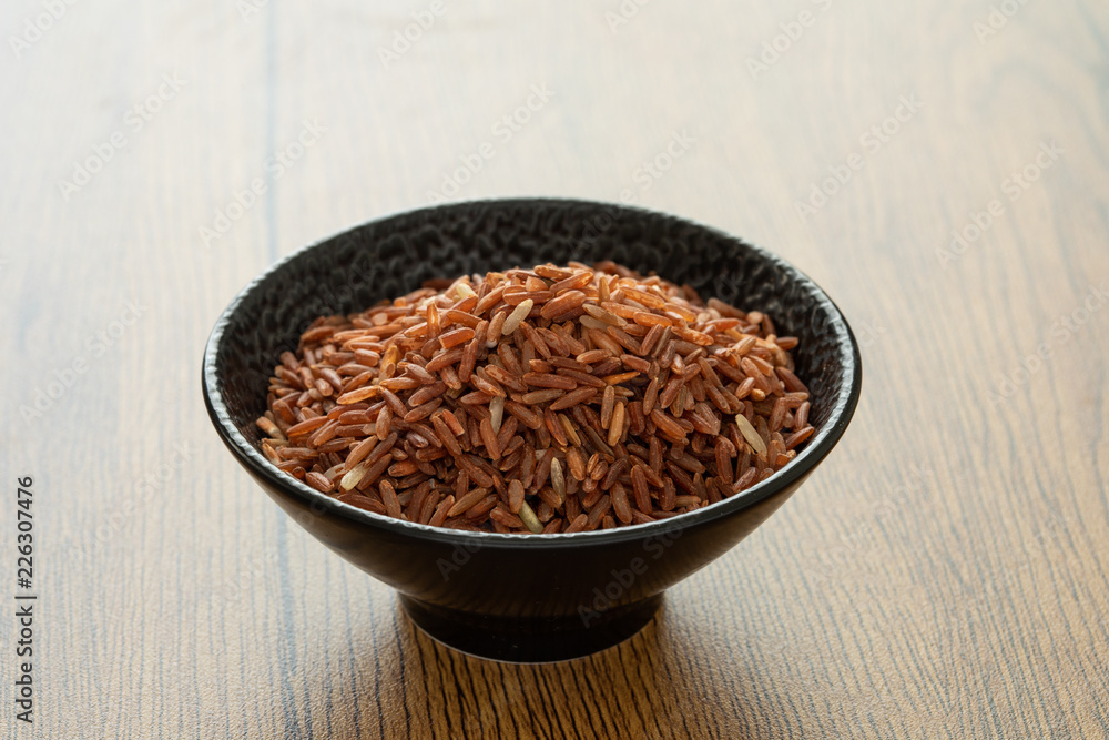 brown rice for healthy black bowl on wood background brown rice for healthy black bowl on wood background