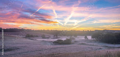 Fototapeta Naklejka Na Ścianę i Meble -  beautiful, multicolored dawn above the panorama of fields and meadows. landscape picture resembling Italian Tuscany. Autumn-Poland, Drawsko Lake District