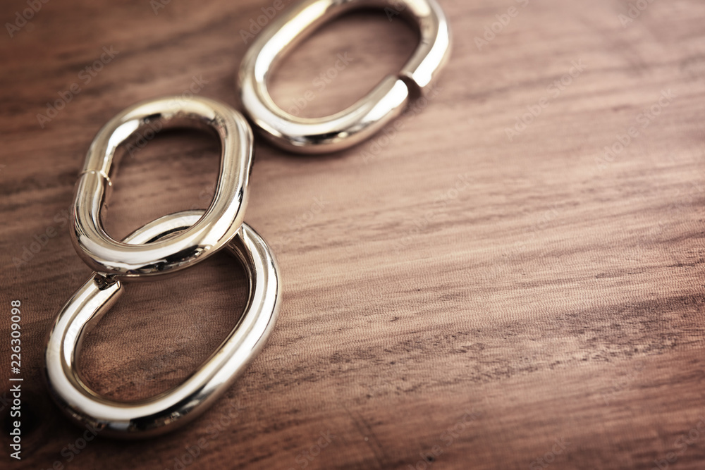 Chain links or chrome metal links on a grungy wooden table. shallow depth of field. Chain links or chrome metal links on a grungy wooden table. shallow depth of field.