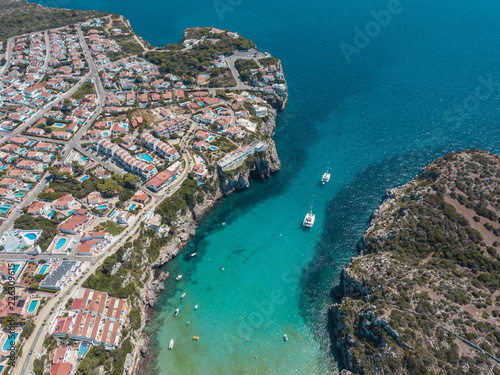 Fototapeta Naklejka Na Ścianę i Meble -  Aerial bird's eye view drone of boat docked in mediterranean tropical beach with turquoise - sapphire waters