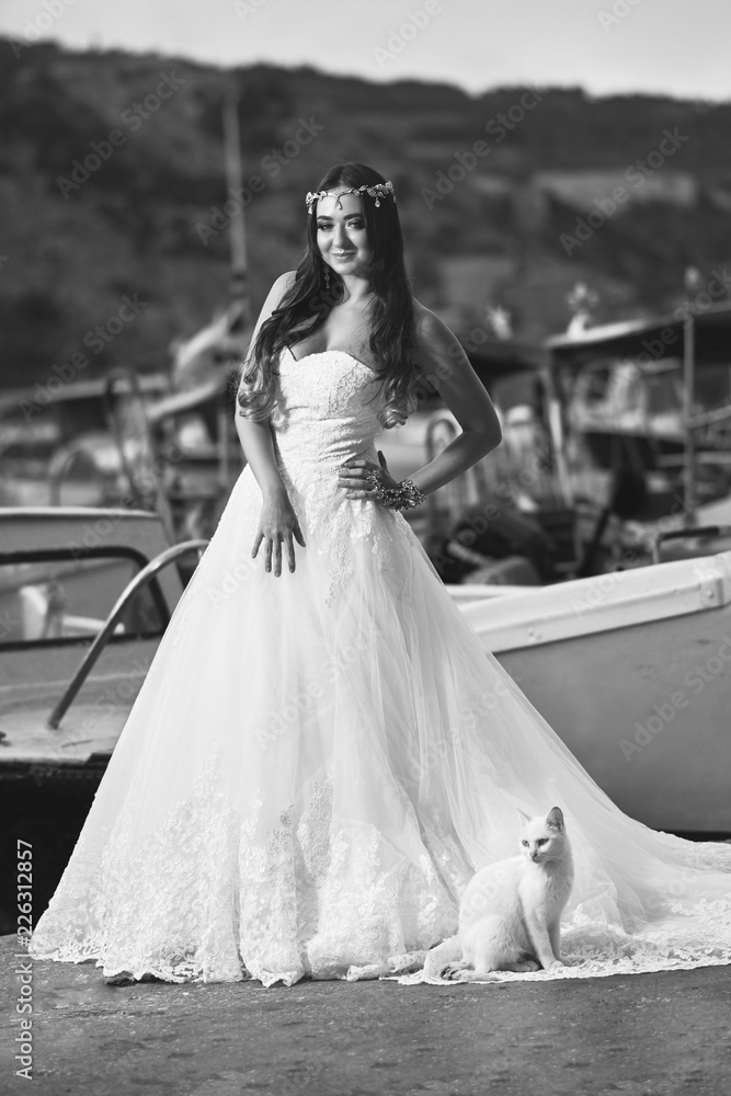 Brunette bride in a long white dress near the sea Brunette bride in a long white dress near the sea