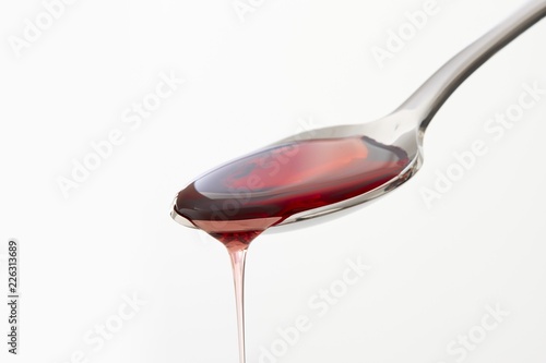 Cough syrup dripping from a spoon photo