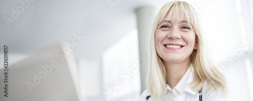 Doctor using computer and smiling