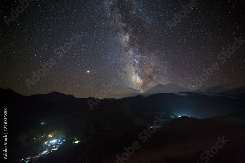 Stars of the Milky Way at night in the sky above Mount Elbrus. View of the northern slope of the two peaks of the stratovolcano. The highest peak of Russia and Europe is 5642m.