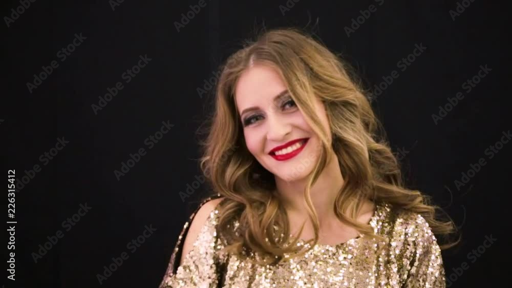girl in a brilliant gold dress on a black background girl in a brilliant gold dress on a black background