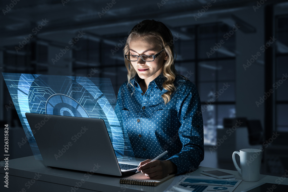Beautiful blonde in dark office working on laptop and getting ne Beautiful blonde in dark office working on laptop and getting ne