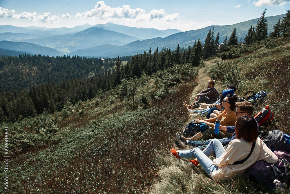 Fototapeta premium Pano shot of a beautiful Carpathian scenery with a group of travelers resting on the hills