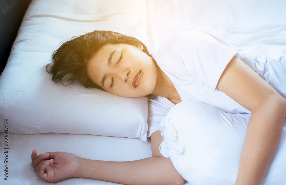 Women sleeping on the bed and grinding teeth,Female tiredness and stress Women sleeping on the bed and grinding teeth,Female tiredness and stress