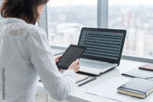 Woman working with tablet pc and laptop computer on table