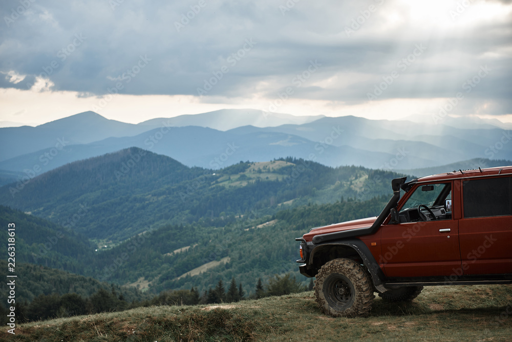 Panoramic view of Carpathian mountains with modern off road car standing on the hills