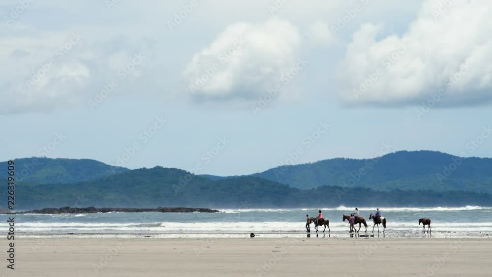 Family riding horses on the seashore slow motion.  Horse ride on the white sands of the beach. Riding on horseback by the sea.