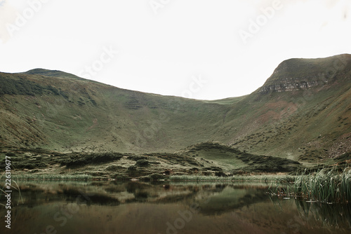 Mountain lake. Panoramic view of the beautiful green hills with little lake in the middle