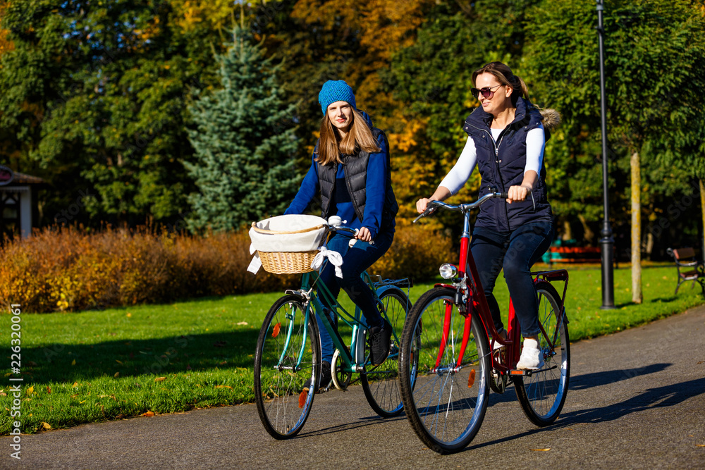 Fototapeta Zdrowy styl życia - ludzie jeżdżący na rowerach w parku miejskim